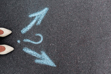 Top View Of Woman Standing Near Directional Arrows And Question Mark On Asphalt