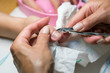 © jollier_ - Woman hands receiving manicure and nail care procedure. Close up concept. Manicurist pushing cuticles on female's nails. female nail manicure processing