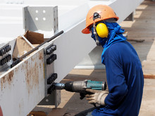 Worker Using A Drill In A Construction Site