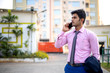 © Abhishek Kumar Sah - Young Indian businessman using Mobile phone in formal dress near office building