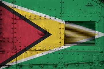 Guyana flag depicted on side part of military armored tank closeup. Army forces conceptual background