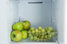 Apples And Grapes On Shelf In Refrigerator