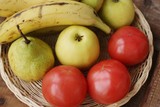 Fototapeta Kuchnia - Fruits and vegetables in a wooden basket on the table