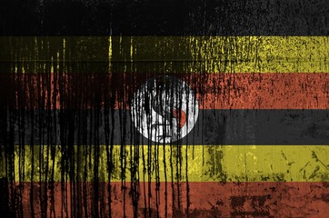 Wall Mural - Uganda flag depicted in paint colors on old and dirty oil barrel wall closeup. Textured banner on rough background