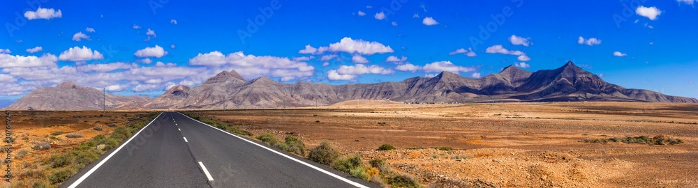 Impressive landscape and deserted roads of volcanic Fuerteventura , Canary islands - obrazy, fototapety, plakaty 