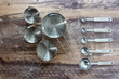 Set of measuring cups and measuring spoon with a handle made from stainless on wooden tabletop in top view