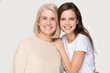 © fizkes - Happy smiling elder mother and millennial daughter posing for portrait