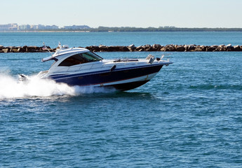 High-end cabin cruiser speeding through Government Cut off Miami Beach,Florida