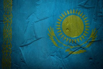 Flag of Kazakhstan on the background of a relief concrete wall.