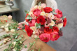 © malkovkosta - European floral shop concept. Florist woman creates red beautiful bouquet of mixed flowers. Handsome fresh bunch. Education, master class and floristry courses. Flowers delivery.