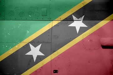 Saint Kitts and Nevis flag depicted on side part of military armored helicopter closeup. Army forces aircraft conceptual background