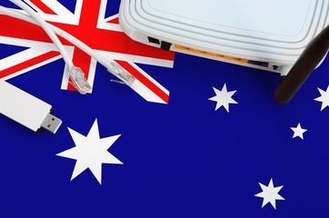 Australia flag depicted on table with internet rj45 cable, wireless usb wifi adapter and router. Internet connection concept