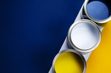 Fototapeta Tulipany - Cans of paint on a background of yellow and classic blue.