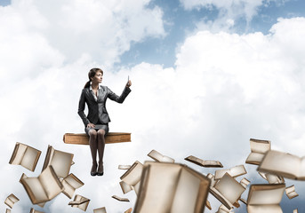 Wall Mural - Attractive girl sitting on book and flying in sky