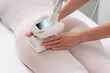 Woman in special white suit getting anti cellulite massage in spa salon. LPG and body contouring treatment