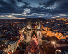 Prague, Czech Republic - Aerial Drone View Of The Famous Illuminated Church Of Our Lady Before Tyn With The Christmas Market, Old Town Hall & Old Town Square At Background By Night