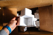 © ifeelstock - Man holding polystyrene packaging detail of a cardboard box during unboxing