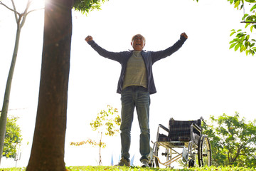 Wall Mural - asian old man standing by wheel chair with joy