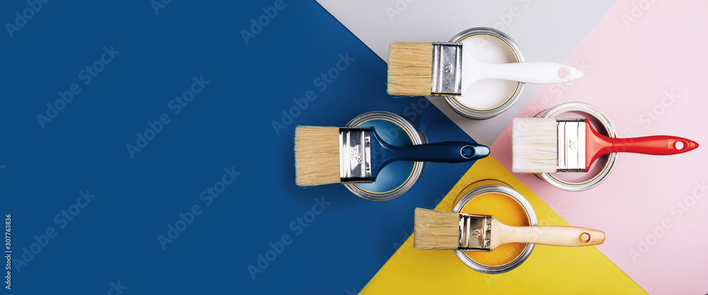 Banner with four open cans of paint with brushes on them on bright symmetry background. Yellow, white, pink, blue colors of paint. Top view. - obrazy, fototapety, plakaty 