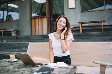 Smiling woman in casual clothes talking on phone