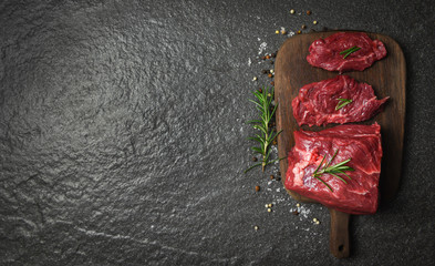 Raw beef steak with herb and spices rosemary / Fresh meat beef sliced on wooden cutting board background