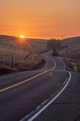 Wall Mural - Twisty road into the sunrise