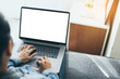 © panitan - mockup image blank screen computer with blank white background for advertising text,hand man using laptop contact business search information on desk at home office.marketing and creative design