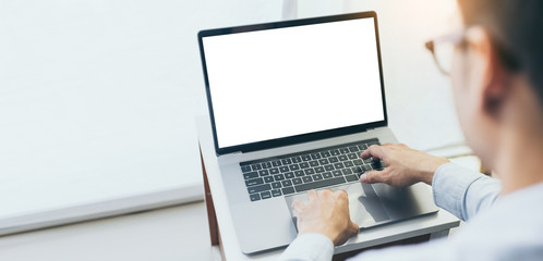 mockup image blank screen computer with blank white background for advertising text,hand man using laptop contact business search information on desk at home office.marketing and creative design