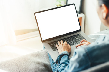 mockup image blank screen computer with blank white background for advertising text,hand man using laptop contact business search information on desk at home office.marketing and creative design