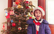 Leinwandbild Motiv Child with cookie infront of Christmas tree