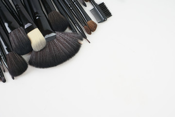 Wall Mural - Top view of Professional makeup brushes over black background. Selective focus