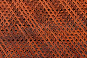 Brown wooden wall lattice background texture.  wooden fence cross pattern. Crossing a tree with nails.