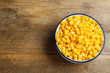 © New Africa - Delicious canned corn in bowl on wooden table, top view. Space for text