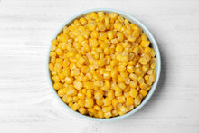 Delicious Canned Corn In Bowl On White Wooden Table, Top View
