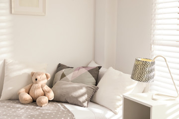 Sticker - Teddy bear on bed in modern child room. Interior design