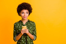Photo Of Beautiful Funny Dark Skin Wavy Lady Hold Telephone Hands Read Good Youth News Look Empty Space Advert Wear Green Dotted Shirt Isolated Yellow Color Background