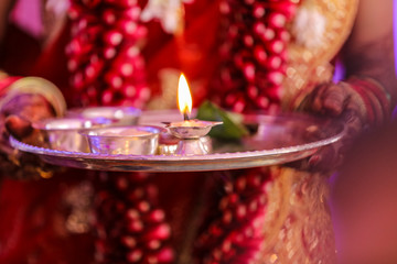 Wall Mural - Traditional indian wedding ceremony in Hinduism : Holding puja thali and oil lamp in hand