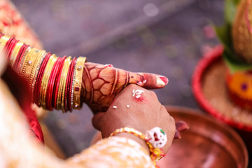 Traditional indian wedding ceremony, groom holding hand in bride hand