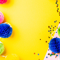 Wall Mural - Festive yellow background with colorful paper balls. Greeting card concept voor birthday, party, invitation, carnival. Copy space, top view, flat lay.