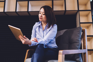 Asian businesswoman reading news on tablet