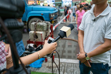 Journalist With Microphone Interviewing On Street Closeup