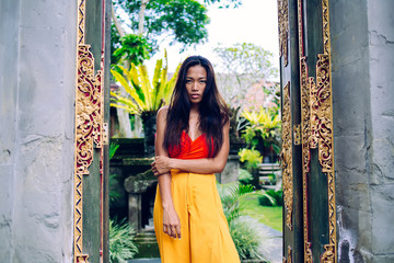 Young Asian female in gates of aged temple