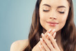 © millaf (Nemchinova) - Pretty woman with manicure nails on blue background, face closeup