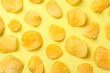 Flat lay composition with potato chips on yellow background, top view