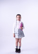 © Watcharin - The little girl holding book in hand,standing on white background,prepare for go to school