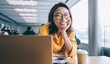 © BullRun - Portrait of Chinese female student smiling at camera during studying day in unoversity classroom, happy hipster girl posing during break from e learning on laptop and exam preparation indoors