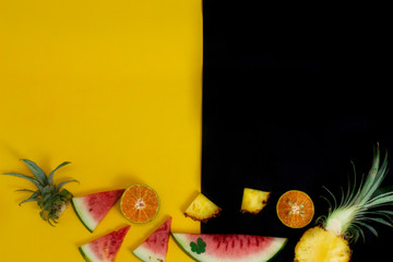 Wall Mural - exotic tropical fruits, pineapple, orange, watermelon isolated on a black yellow background