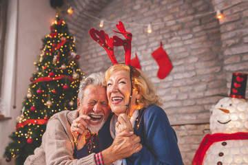 Wall Mural - Senior couple having fun while decorating home for Christmas