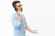 © Mangostar - Annoyed guy speaking on mobile phone, arguing with talk partner. Handsome young man in casual shirt and glasses standing isolated over white background. Phone talk concept