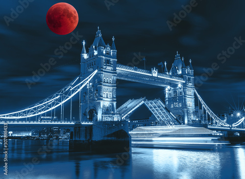 tower-bridge-at-night-collage-with-a-bloody-moon-and-thames-long-exposure-light-of-boat-when-it-passes-through-bridge-london-photo-blurred-and-tinted-in-classic-blue-color-of-the-year-2020